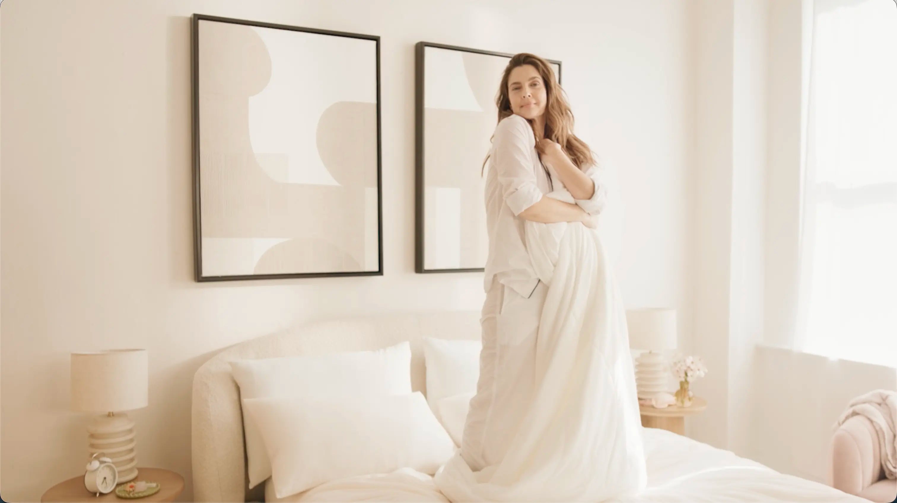 Woman standing in a bedroom in a flowing dress